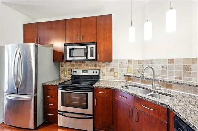 kitchen with appliances with stainless steel finishes, stone countertops, decorative backsplash, and a sink