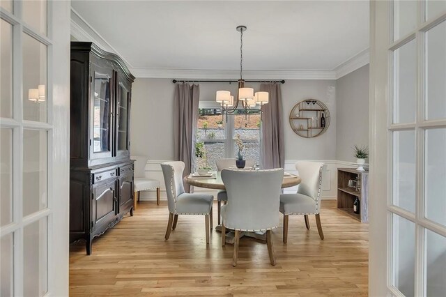 809 Hillcrest Ln, Woodstock, GA 30189 - dining room with arched walkways, a chandelier, ornamental molding, light wood finished floors, and wainscoting
