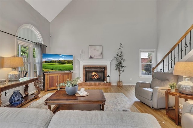 809 Hillcrest Ln, Woodstock, GA 30189 - living area with high vaulted ceiling, plenty of natural light, light wood-style flooring, a brick fireplace, and stairway