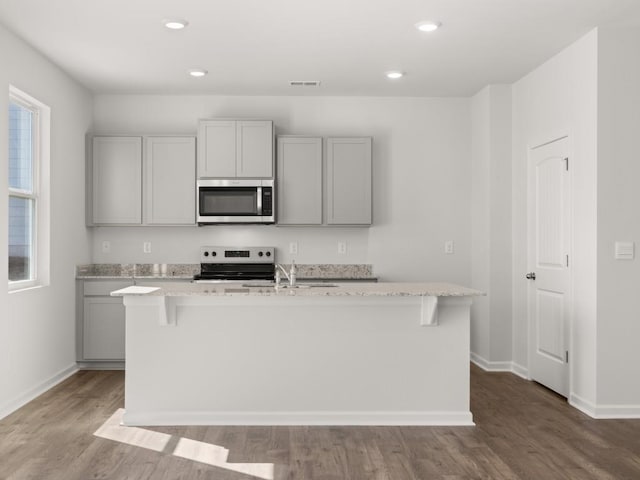 13 Coggins Pl, Rome, GA 30165 - kitchen featuring appliances with stainless steel finishes, a sink, wood finished floors, baseboards, and light stone countertops