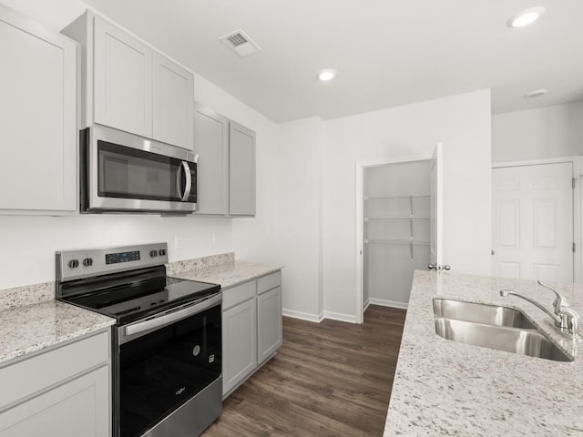 13 Coggins Pl, Rome, GA 30165 - kitchen featuring stainless steel appliances, a sink, baseboards, dark wood finished floors, and light stone counters