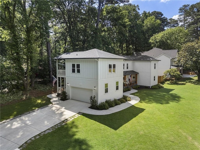 3899 Carlton Dr, Chamblee, GA 30341 - view of front of home with board and batten siding, a garage, driveway, a front lawn, and view of wooded area