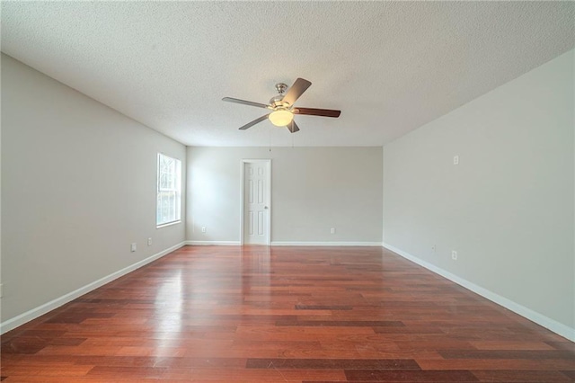 spare room featuring a textured ceiling, ceiling fan, wood finished floors, and baseboards