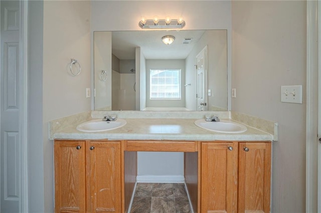 bathroom with double vanity, a shower, and a sink