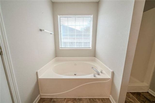 bathroom featuring a garden tub, baseboards, and a walk in shower