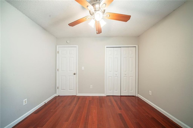 unfurnished bedroom featuring ceiling fan, a closet, baseboards, and wood finished floors