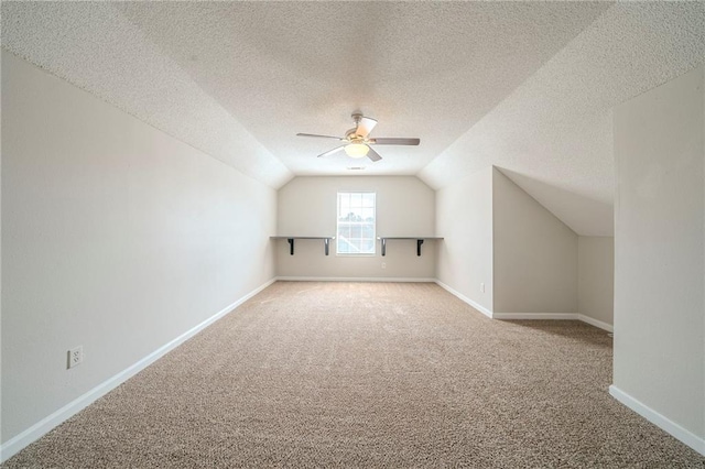 bonus room with carpet floors, baseboards, vaulted ceiling, and a ceiling fan