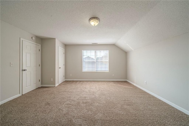 bonus room featuring carpet, a textured ceiling, and baseboards