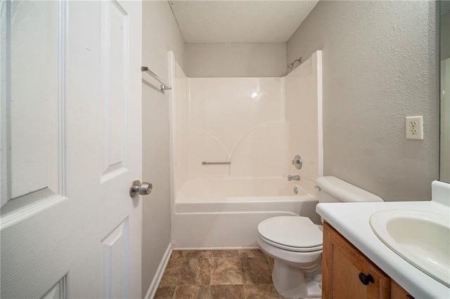 bathroom featuring a textured ceiling, a textured wall, shower / bathtub combination, toilet, and vanity