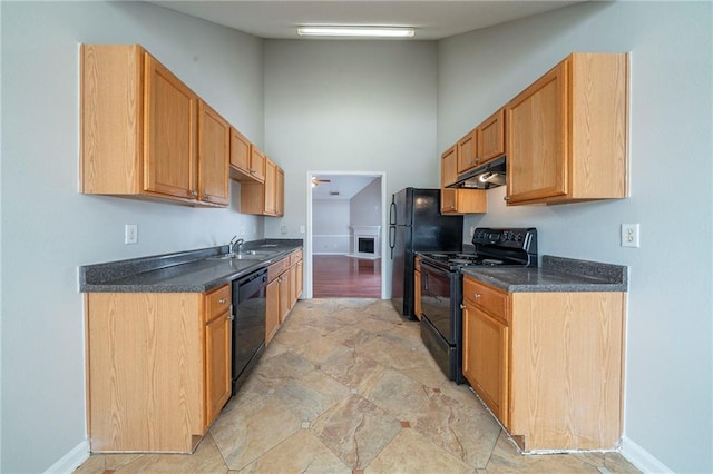 kitchen with dark countertops, under cabinet range hood, black appliances, high vaulted ceiling, and a sink