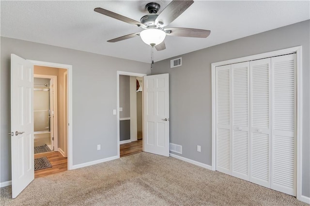 unfurnished bedroom featuring carpet flooring, ceiling fan, and a closet