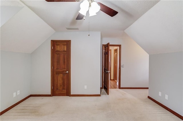 additional living space with lofted ceiling, light colored carpet, and ceiling fan