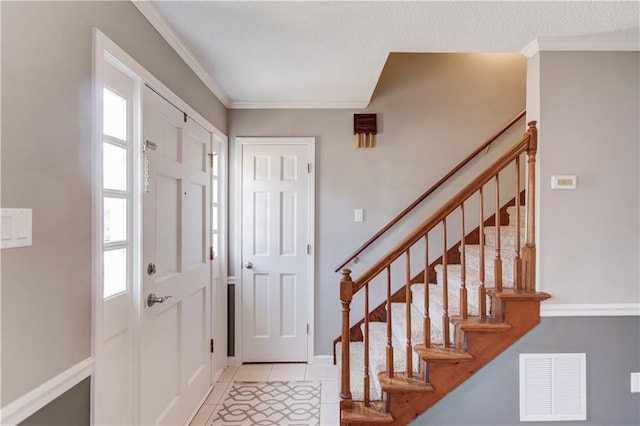 foyer entrance with light tile patterned flooring and crown molding