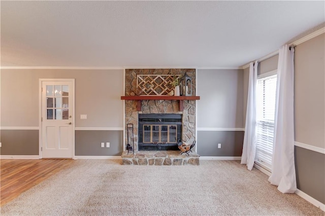 unfurnished living room with crown molding, a fireplace, and carpet