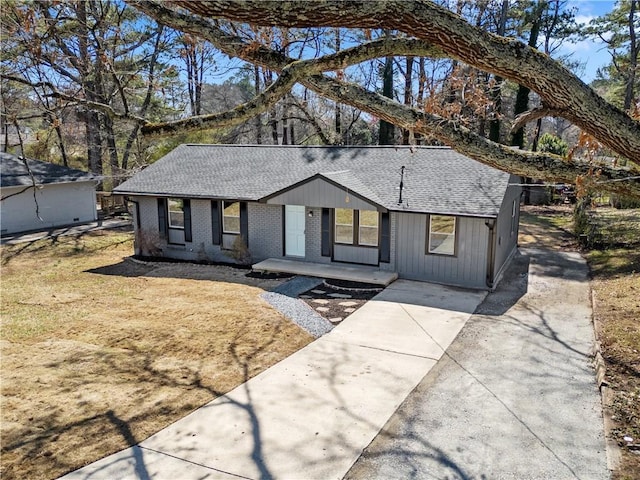 view of front of home featuring brick siding and roof with shingles