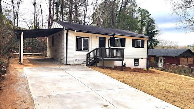 view of front facade featuring an attached carport, driveway, a front yard, and fence