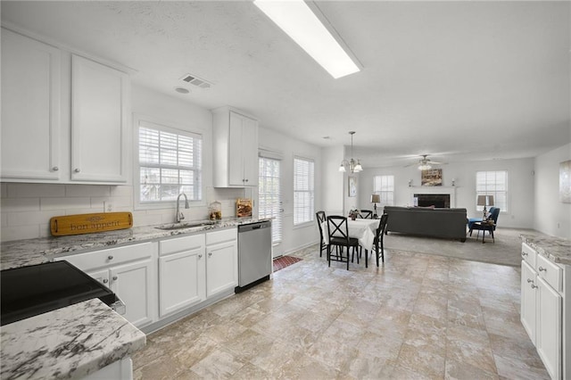 kitchen featuring dishwasher, a sink, electric stove, a healthy amount of sunlight, and a fireplace