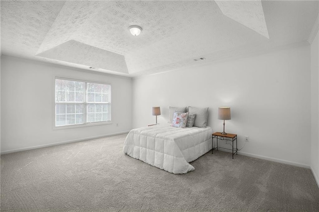 bedroom with a tray ceiling, a textured ceiling, visible vents, carpet flooring, and baseboards