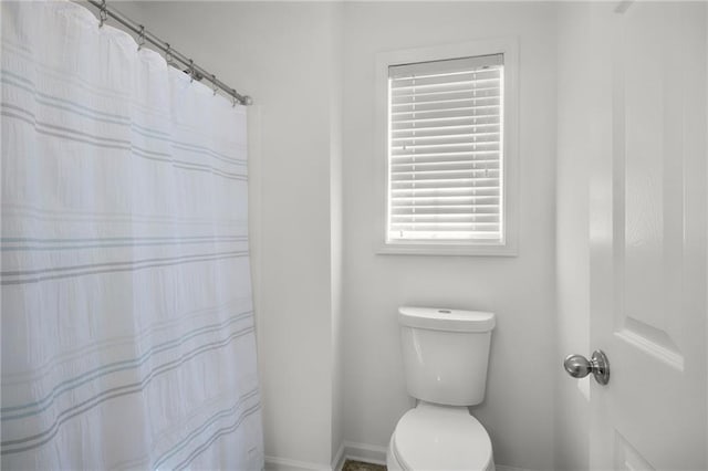 full bathroom with toilet, baseboards, and a shower with curtain