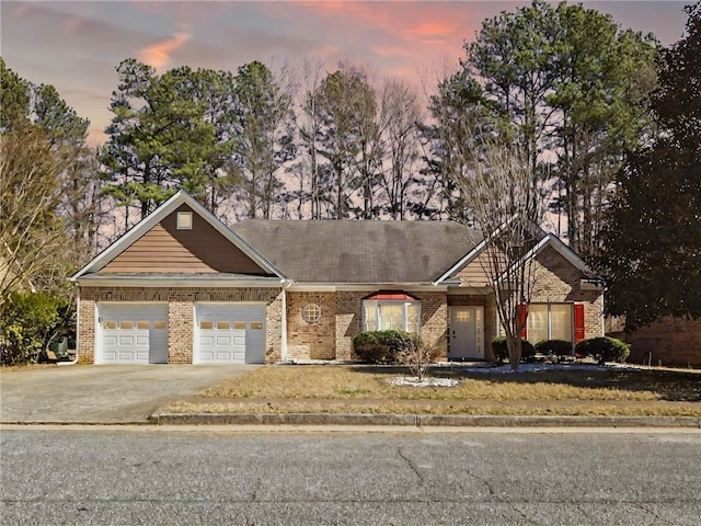 view of front of house featuring a garage, brick siding, and driveway