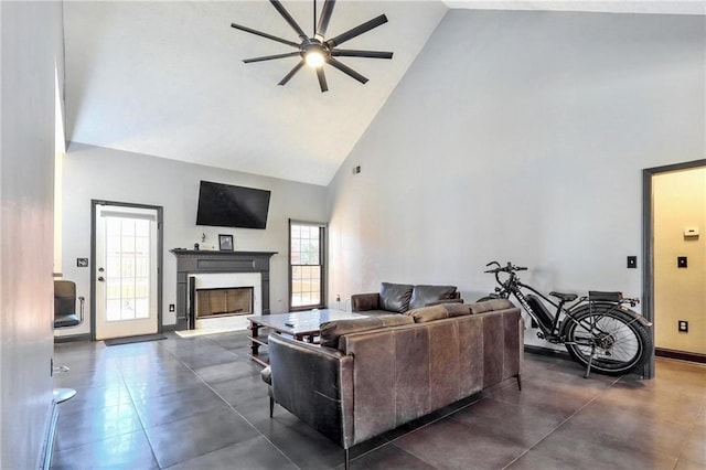 living area with high vaulted ceiling, a fireplace, baseboards, and a ceiling fan