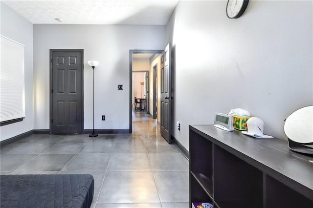 interior space featuring a textured ceiling and baseboards