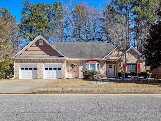 view of front of home featuring driveway, an attached garage, and brick siding