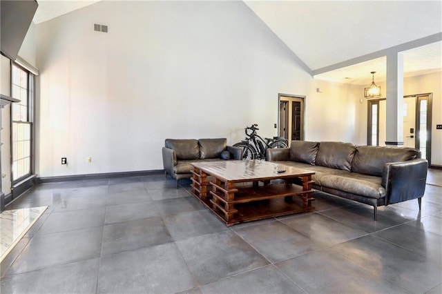 living room with high vaulted ceiling, visible vents, and baseboards