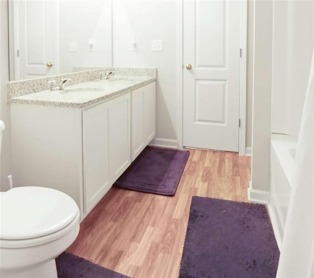 20 Sloane Ct, Covington, GA 30016 - bathroom with toilet, wood finished floors, double vanity, and baseboards