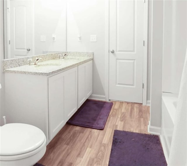 20 Sloane Ct, Covington, GA 30016 - full bath featuring toilet, wood finished floors, double vanity, and baseboards