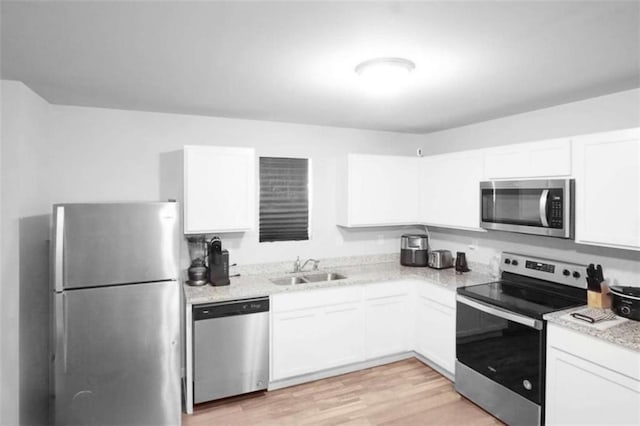 20 Sloane Ct, Covington, GA 30016 - kitchen with appliances with stainless steel finishes, a sink, white cabinets, and light wood finished floors