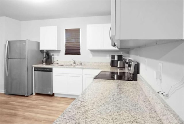20 Sloane Ct, Covington, GA 30016 - kitchen with appliances with stainless steel finishes, a sink, white cabinets, light wood finished floors, and light countertops