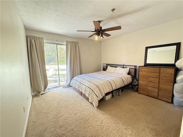 bedroom with ceiling fan, access to exterior, carpet floors, and a textured ceiling