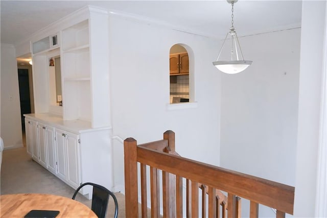 hallway with crown molding and light carpet