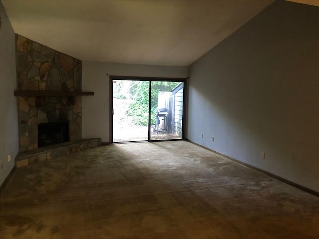unfurnished living room featuring carpet floors, vaulted ceiling, baseboards, and a fireplace