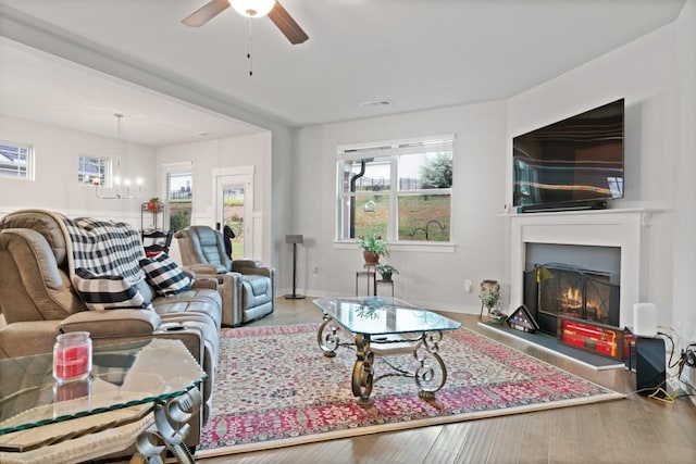 living room featuring wood-type flooring, plenty of natural light, and ceiling fan