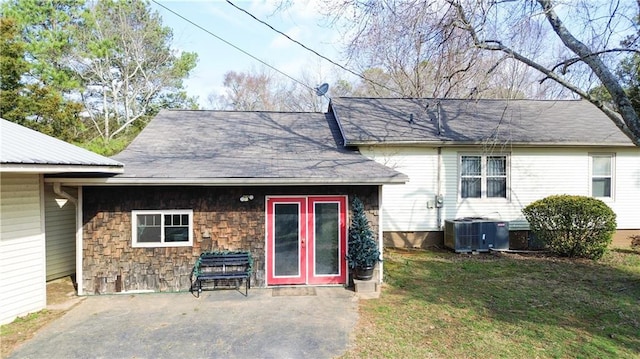 rear view of property featuring a patio area, central air condition unit, and a lawn