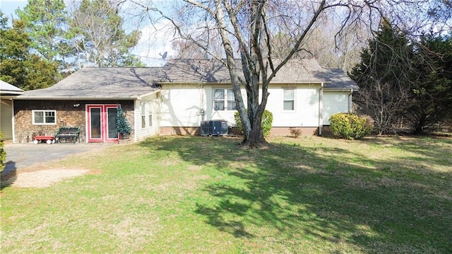 rear view of property with cooling unit, a yard, and a patio