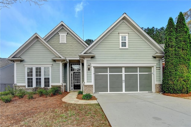 craftsman house with driveway, brick siding, and a garage