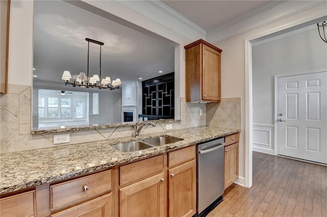 kitchen with ornamental molding, backsplash, a sink, light stone counters, and dishwasher