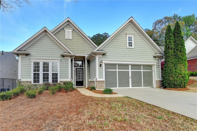 craftsman-style house with fence, a garage, brick siding, and concrete driveway