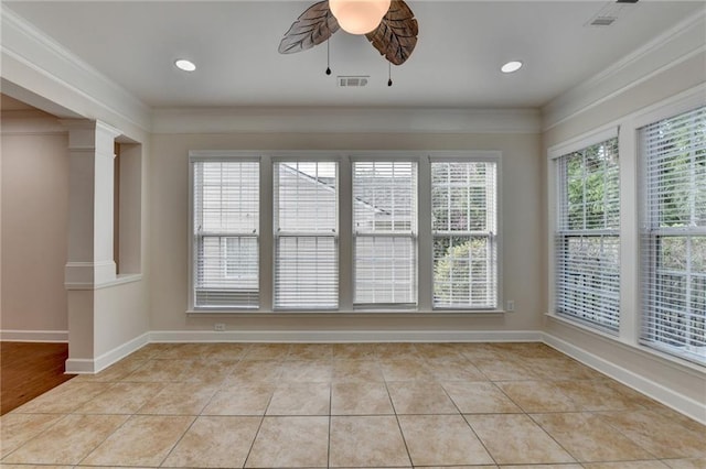 spare room featuring a ceiling fan, crown molding, baseboards, and ornate columns