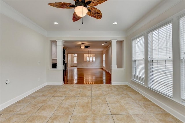 empty room with light tile patterned flooring, decorative columns, ceiling fan, and ornamental molding