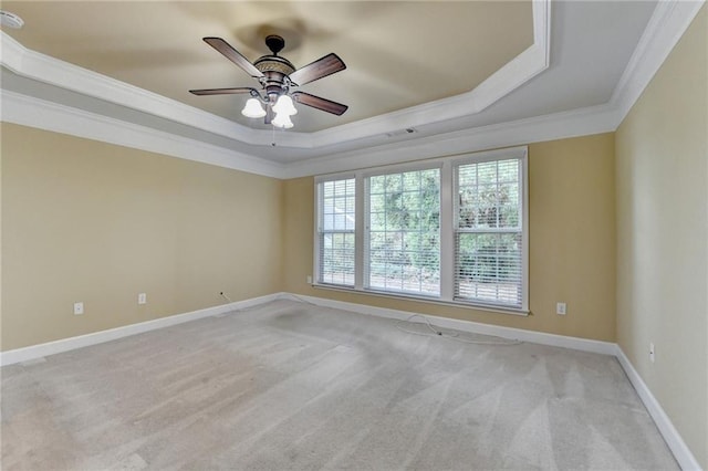 unfurnished room featuring baseboards, ceiling fan, ornamental molding, a tray ceiling, and light colored carpet