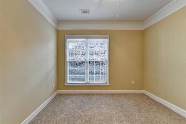 empty room featuring baseboards, visible vents, and crown molding