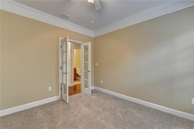 unfurnished bedroom with carpet flooring, visible vents, crown molding, baseboards, and french doors