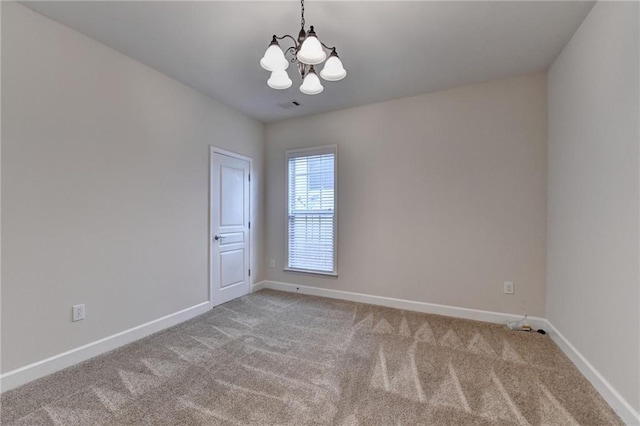 spare room featuring baseboards, visible vents, carpet flooring, and a chandelier