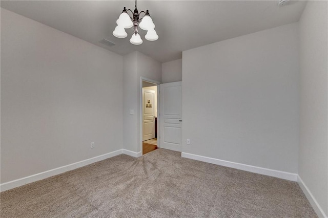 unfurnished room with baseboards, visible vents, carpet floors, and an inviting chandelier
