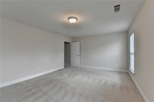 unfurnished room with baseboards, visible vents, and light carpet