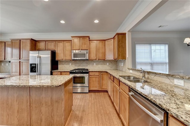 kitchen featuring decorative backsplash, a sink, light wood-style floors, and appliances with stainless steel finishes